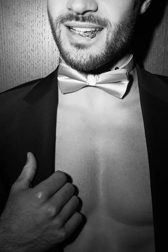 Schwarzweißfoto eines Mannes im Smoking mit weißer Fliege
