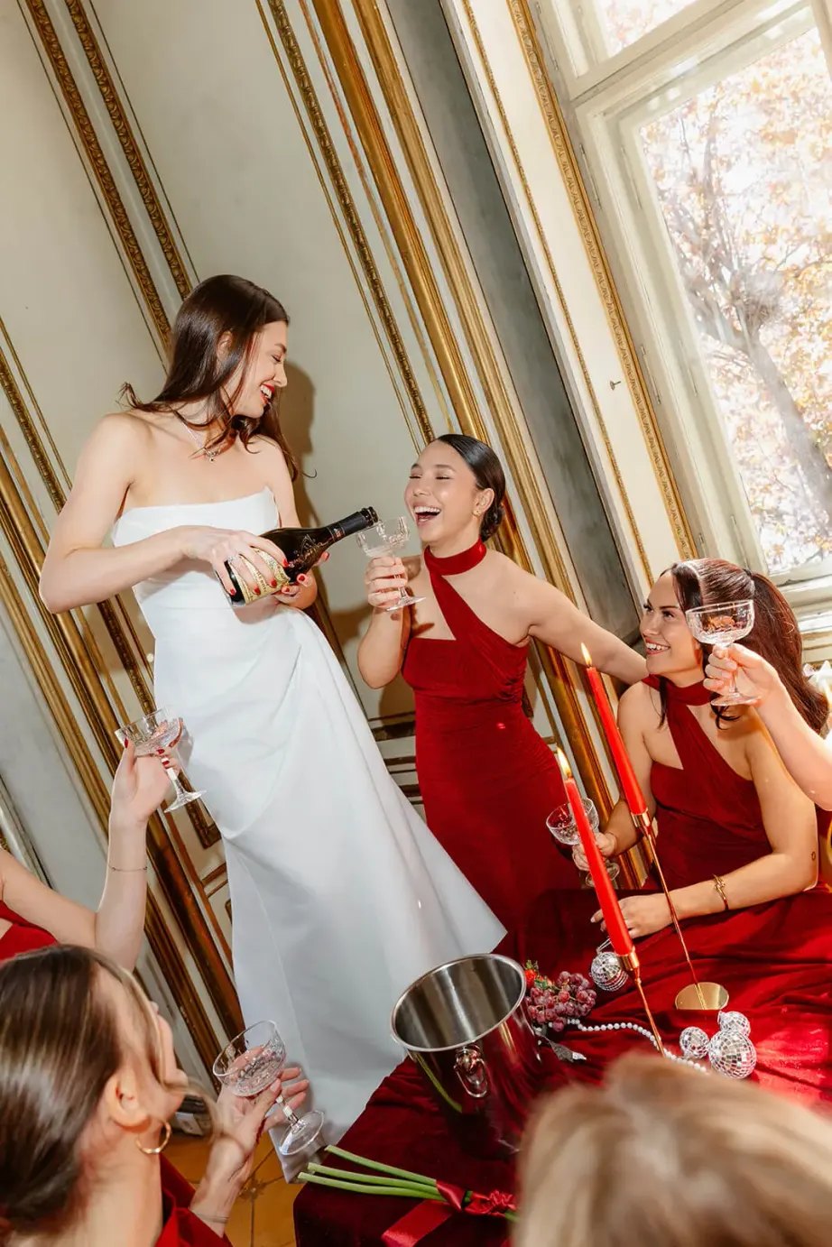 Braut mit Champagner, umringt von Brautjungfern